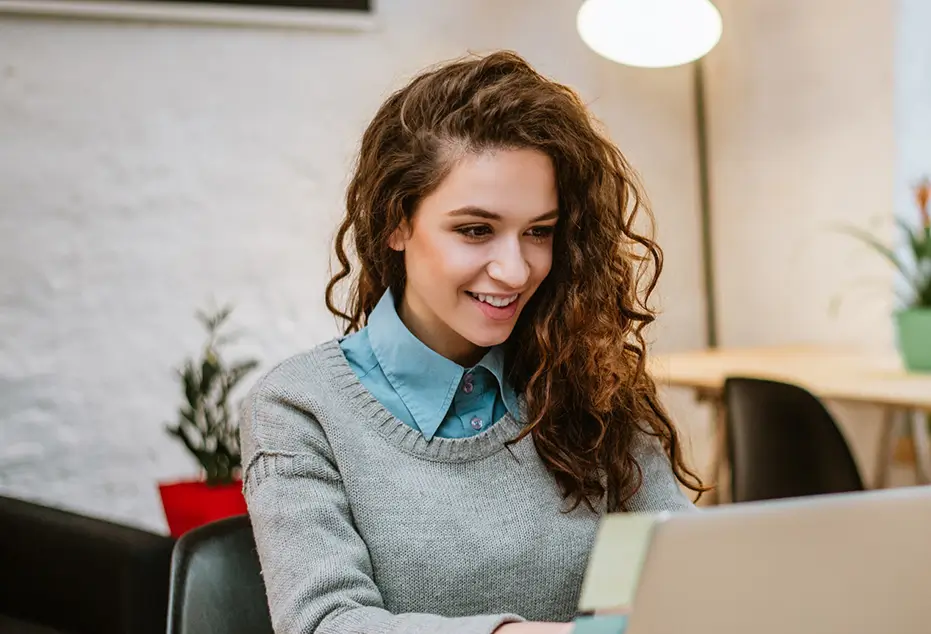 A background image featuring a young woman sitting at a laptop computer.